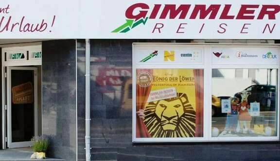 Das Bild zeigt die Schaufensterfront der RMV-Mobibilitäts-Info der Gimmler Wetzlarer Verkehrsbetriebe in der Bannstraße in Wetzlar. Es handelt sich um eine typische Geschäftsfassade in der Innenstadt.