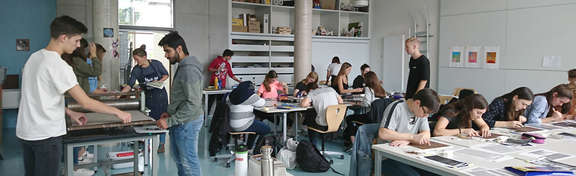 Schüler eines Kunstkurses arbeiten an ihren Werken 