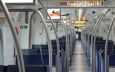 Vergrößerte Ansicht: Blick durch den Innenraum einer modernisierten S-Bahn der Baureihe ET 423 mit Informationsmonitoren