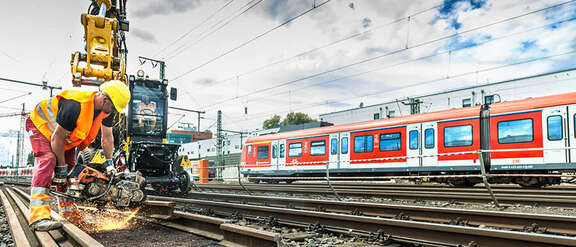 Ein Bauarbeiter führt Schweißarbeiten an Bahngleisen durch