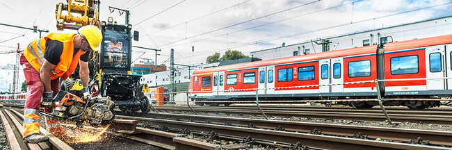 Ein Bauarbeiter führt Schweißarbeiten an Bahngleisen durch