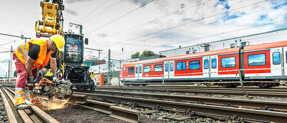 Ein Bauarbeiter führt Schweißarbeiten an Bahngleisen durch