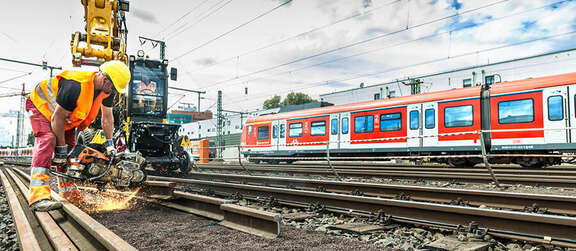 Ein Bauarbeiter führt Schweißarbeiten an Bahngleisen durch