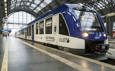 Blau-weißer Triebwagen in Bahnhofshalle