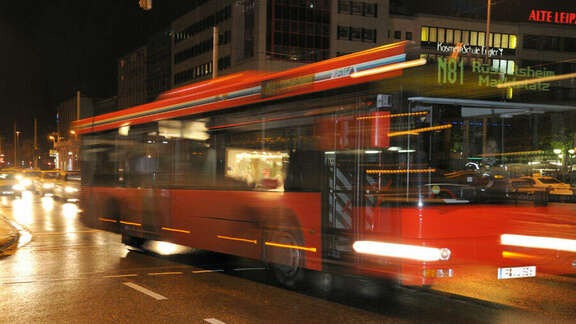 Red bus number N81 driving by night