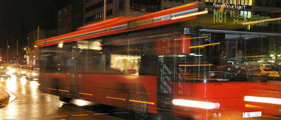 Red bus number N81 driving by night