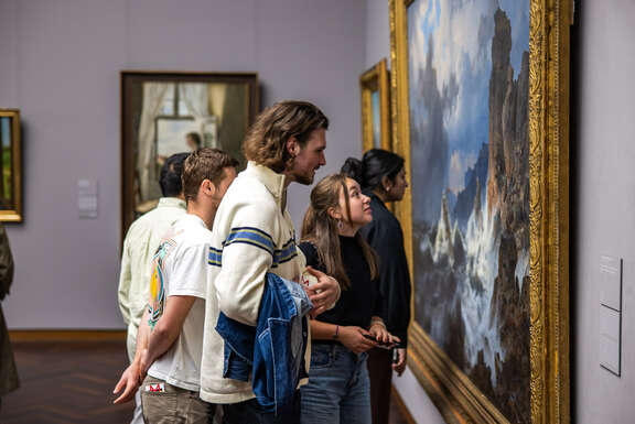 mehrere Menschen betrachten ein Gemälde im Städel Museum