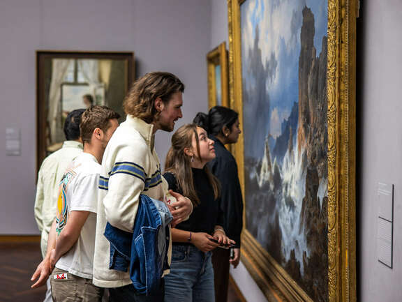 mehrere Menschen betrachten ein Gemälde im Städel Museum