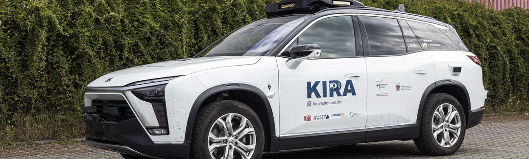 KIRA Weißer SUV mit KIRA-Schriftzug auf der Vordertür und Sensoren auf dem Dach