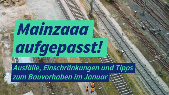 Mehrere Bahngleise eines Vorfeldes mit Abzweigungen. Auf einem Gleis steht eine blaue Diesel-Lock. Links oben im Bild steht ein Bagger in einer ausgehobenen Baugrube
