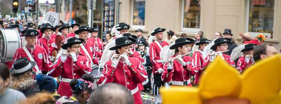 Ein rot gekleideter Spielmannszug zieht an Fastnacht durch die Straßen