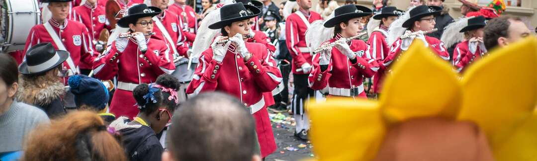 Ein rot gekleideter Spielmannszug zieht an Fastnacht durch die Straßen