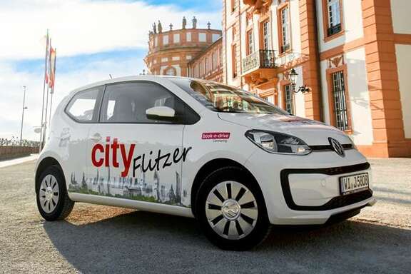 Weißes Auto mit "City Flitzer" Logo von book-n-drive