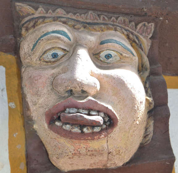 Haus der sieben Laster - Unmäßigkeit Fratze mit rausgestreckter Zunge an einer Hauswand
