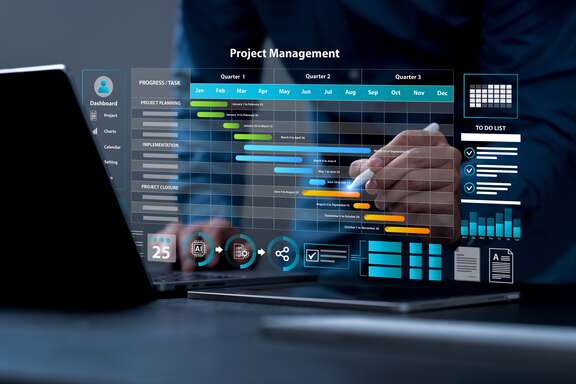 Person arbeitet am Laptop mit digitalem Projektmanagement-Dashboard