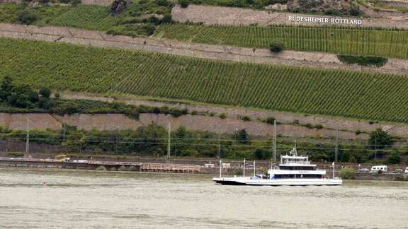 Ferry boat on the Rhine. In the background green hills with vineyard