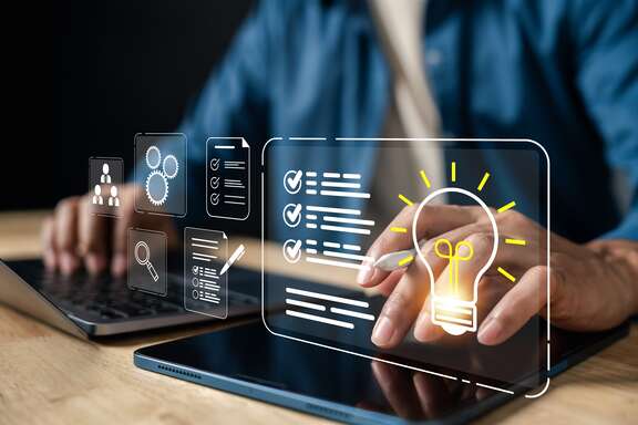 Hand bedient Tablet mit Checklisten und leuchtender Glühbirne als Ideensymbol