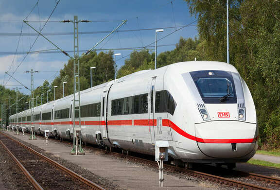 weißer ICE-Zug mit seitlichem rotem Streifen auf Bahngleisen