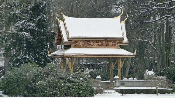 Asiatischer kleiner Tempel inmitten von verschneiten Bäumen