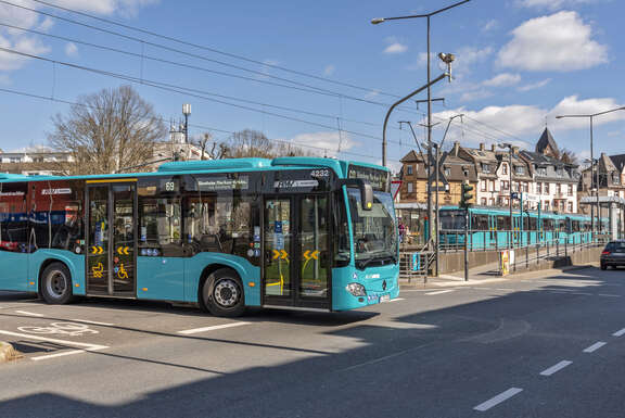 Ein blauer Bus biegt an einer Kreuzung nach links ab.