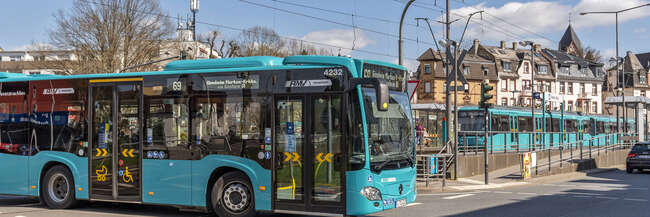 Ein blauer Bus biegt an einer Kreuzung nach links ab.