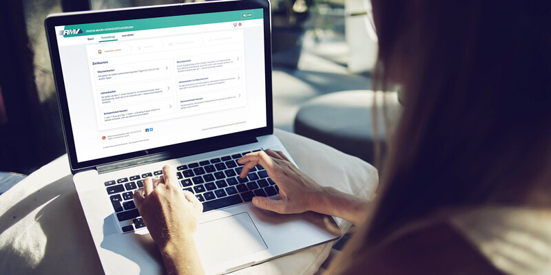 Frau vor einem Laptop mit geöffnetem RMV-Ticketshop