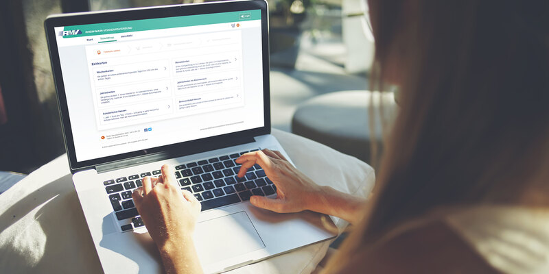 Mädchen vor einem Laptop mit geöffnetem RMV Ticketshop