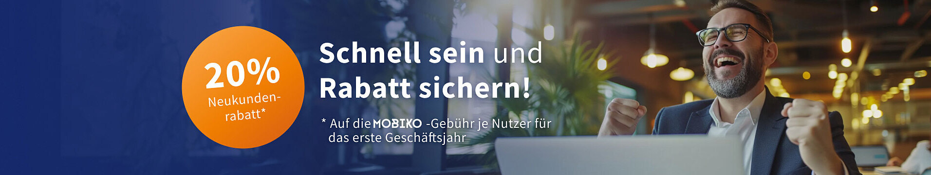 Mann sitzt jubelnd vor Laptop.