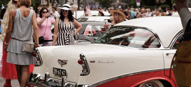 Menschenmenge steht um Oldtimer-Auto.