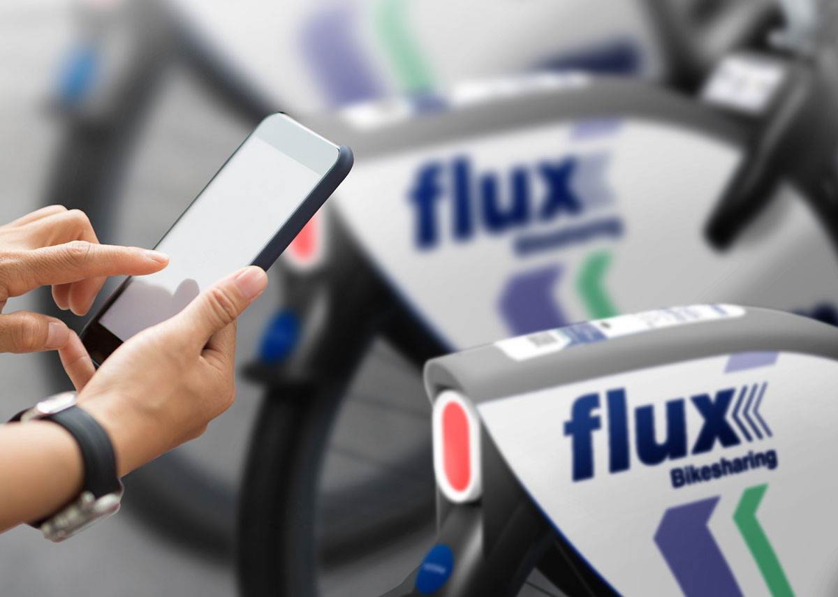 Person scannt mit Smartphone den QR-Code eines flux-Fahrrads.
