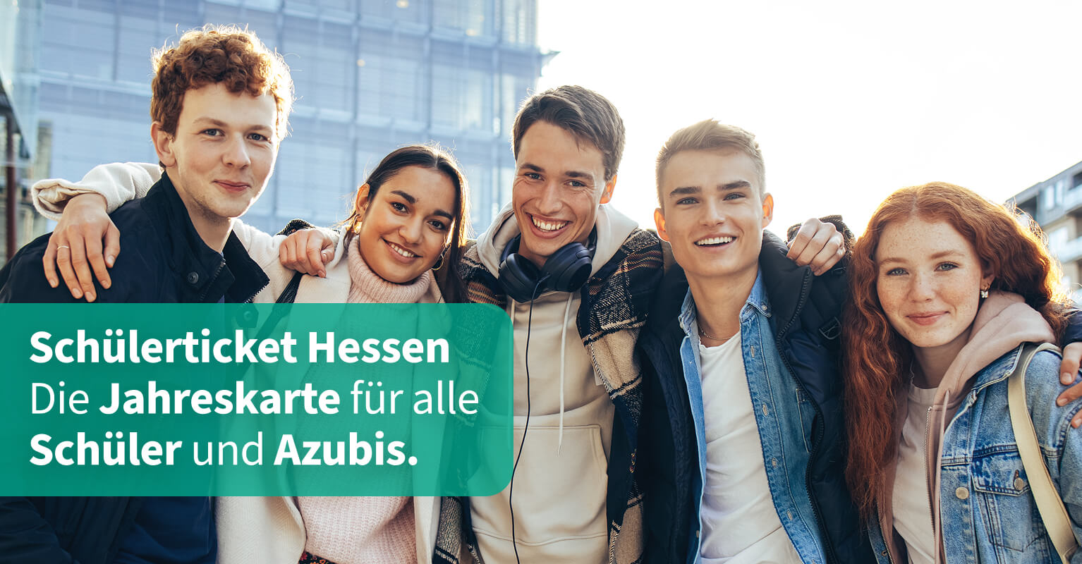 Drei Jungs und zwei Mädchen stehen Arm in Arm vor Schulgebäude
